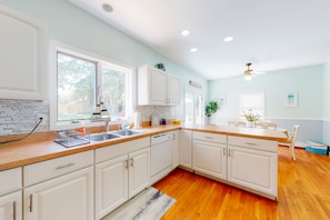 Enjoy cooking in this well-lit kitchen with a large island, double sink, and ample storage space.