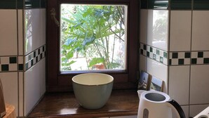 Una cocina con una ventana, un bol y un hervidor.