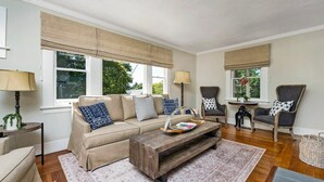 A living room with a beige sofa, two armchairs, a coffee table, and a patterned rug. - The Oxbow House - Designer 3BD/2BA Home (Napa)