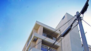 Un edifici d'àmbit urbà amb balcons, una botiga i senyalització visible.