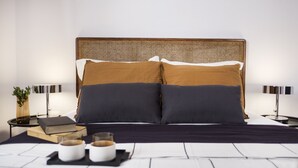 A neatly arranged bedroom with a large bed, two bedside tables, and a bedside lamp on each side. - Live Life Ermou (Athens)