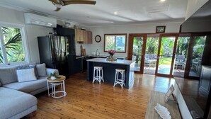A modern kitchen with a central island, wooden flooring, and a view of the outdoors. - The Miami Beach vacation home (Miami)
