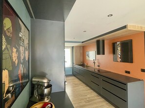 A modern kitchen with a mixer, a sink, and a wooden countertop.