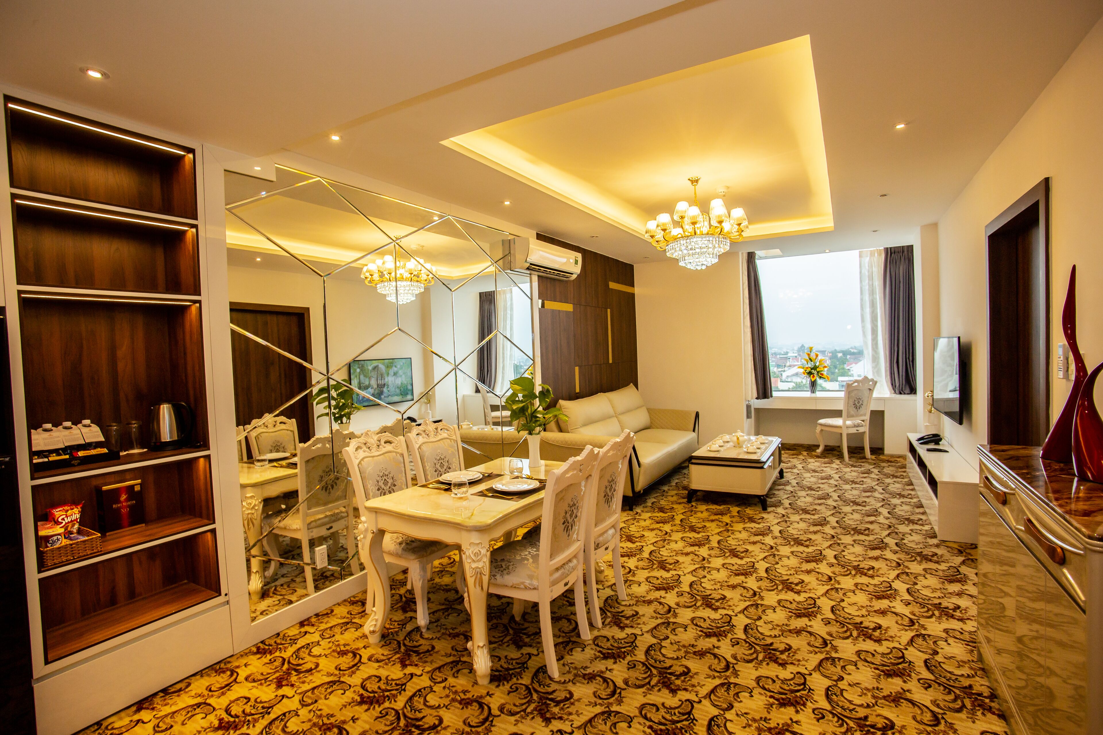 A modern living room with a dining area, a sofa, a TV, and a large mirror.