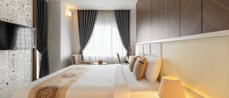 Une chambre d’hôtel avec un grand lit, une lampe de chevet, une tête de lit décorative et une vue sur l’extérieur par la fenêtre.