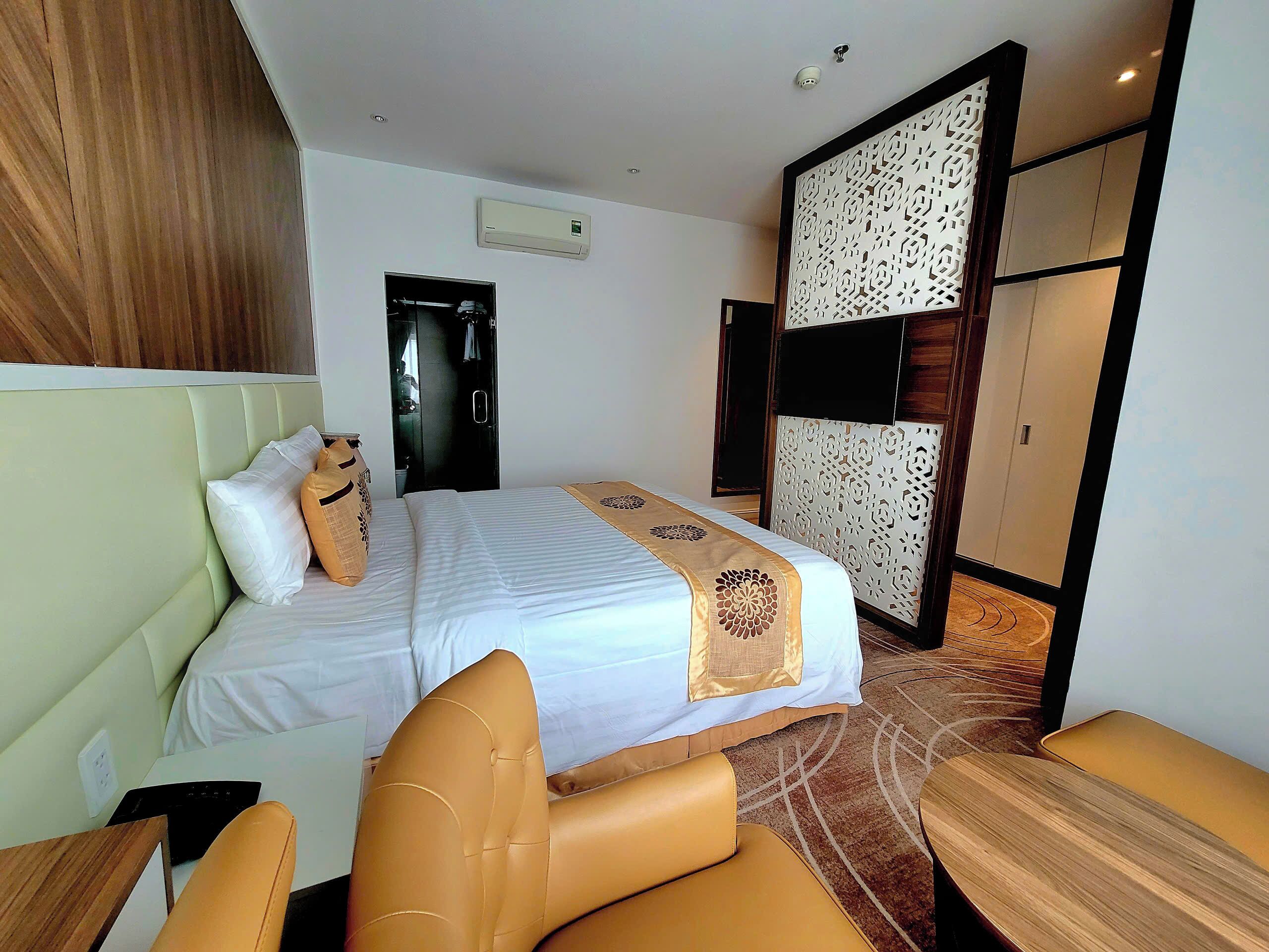 A hotel room with a bed, a desk, and a seating area.