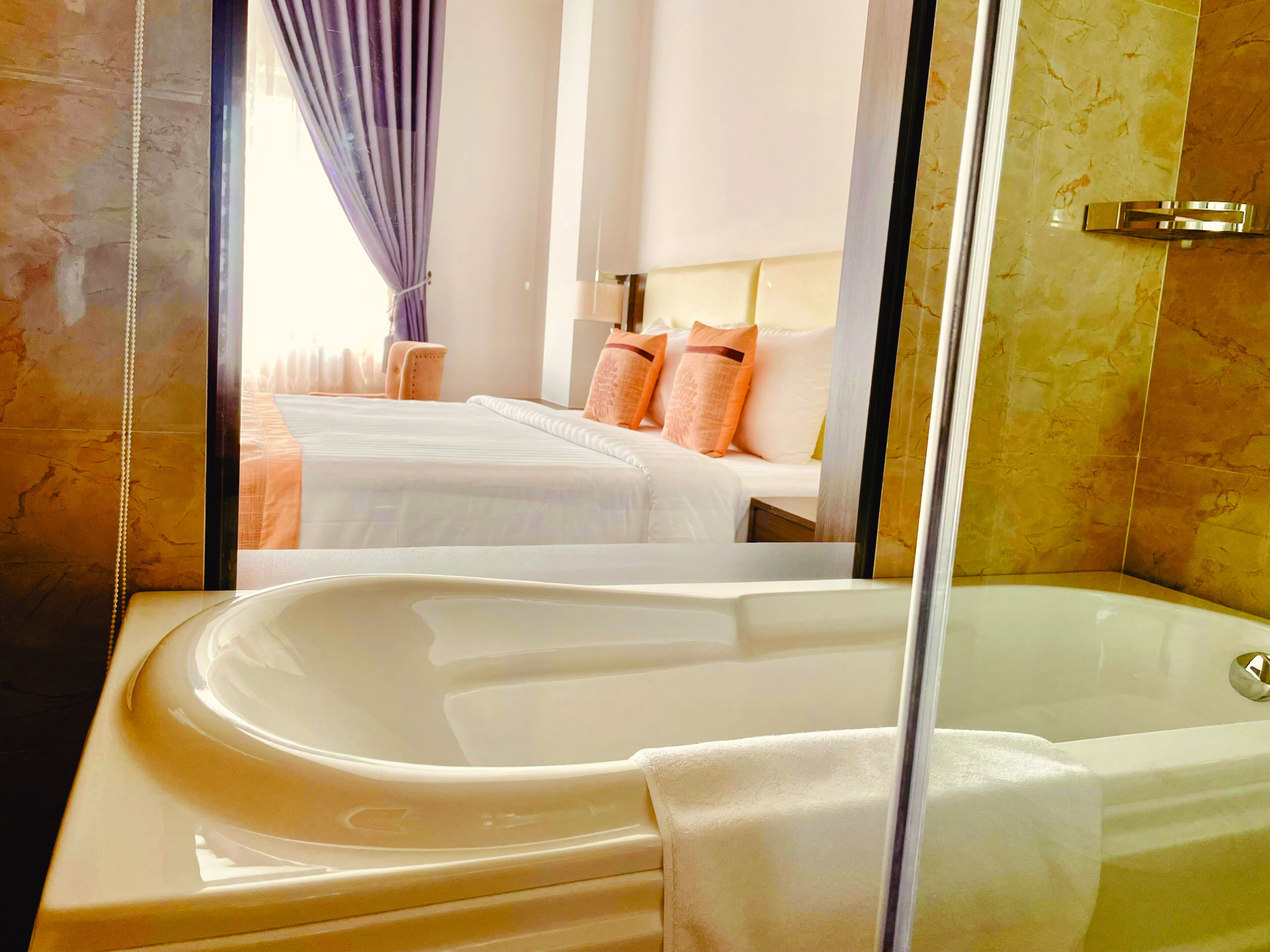 A bathroom with a bathtub, a mirror, and a shower area.