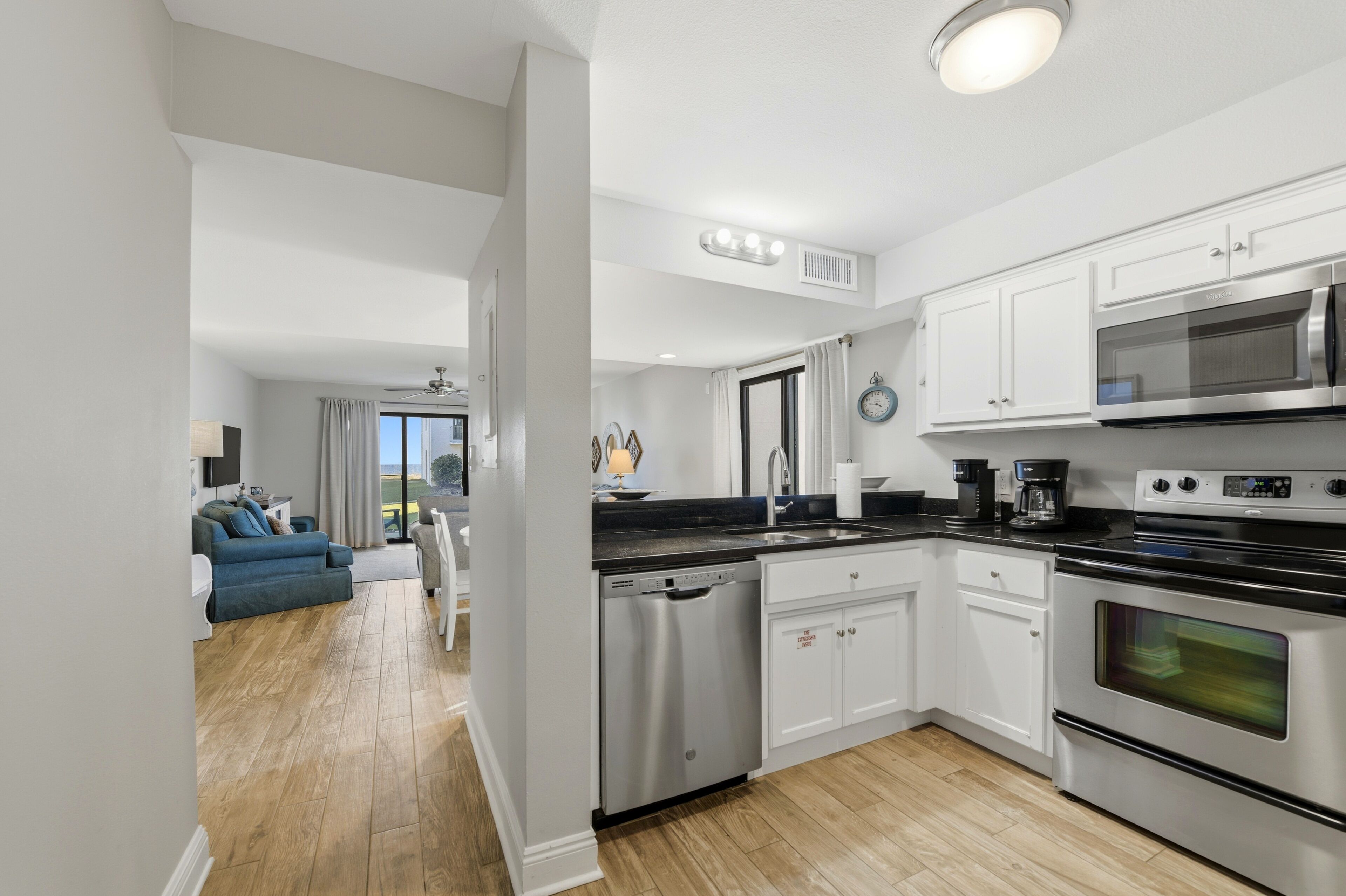 A modern kitchen with stainless steel appliances, white cabinetry, and a dishwasher.