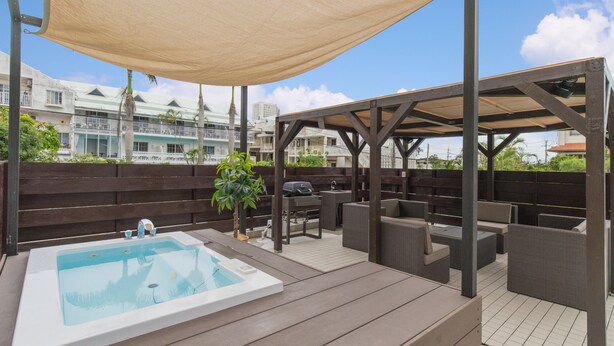 A rooftop pool area with a hot tub, outdoor seating, and a pergola providing shade. - Villa Garden Onna (Onna)