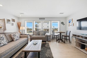 A modern living room with a sofa, coffee table, and dining area.