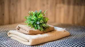 A neatly folded beige towel on a patterned fabric surface. - IKIDANE Residential Hotel Komagome (Tokyo)