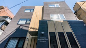 A modern building with a sign for the "Ikidane Residential Hotel Komagome." - IKIDANE Residential Hotel Komagome (Tokyo)