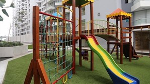 Ein Spielplatz mit Rutsche, Kletternetz und Holzelementen.