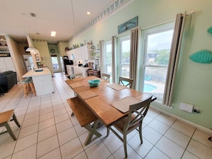 A spacious kitchen with a dining area, large windows, and a view of the outdoors.