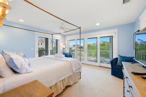 Ein Schlafzimmer mit Himmelbett, Schreibtisch und Blick ins Freie.