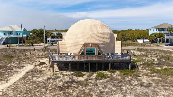 A dome-shaped building with a deck and outdoor seating area.