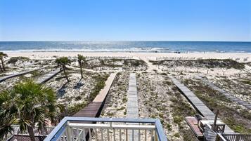 A beach with wooden walkways and palm trees.