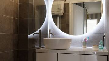 Ducha y bañera combinadas, toallas y papel higiénico