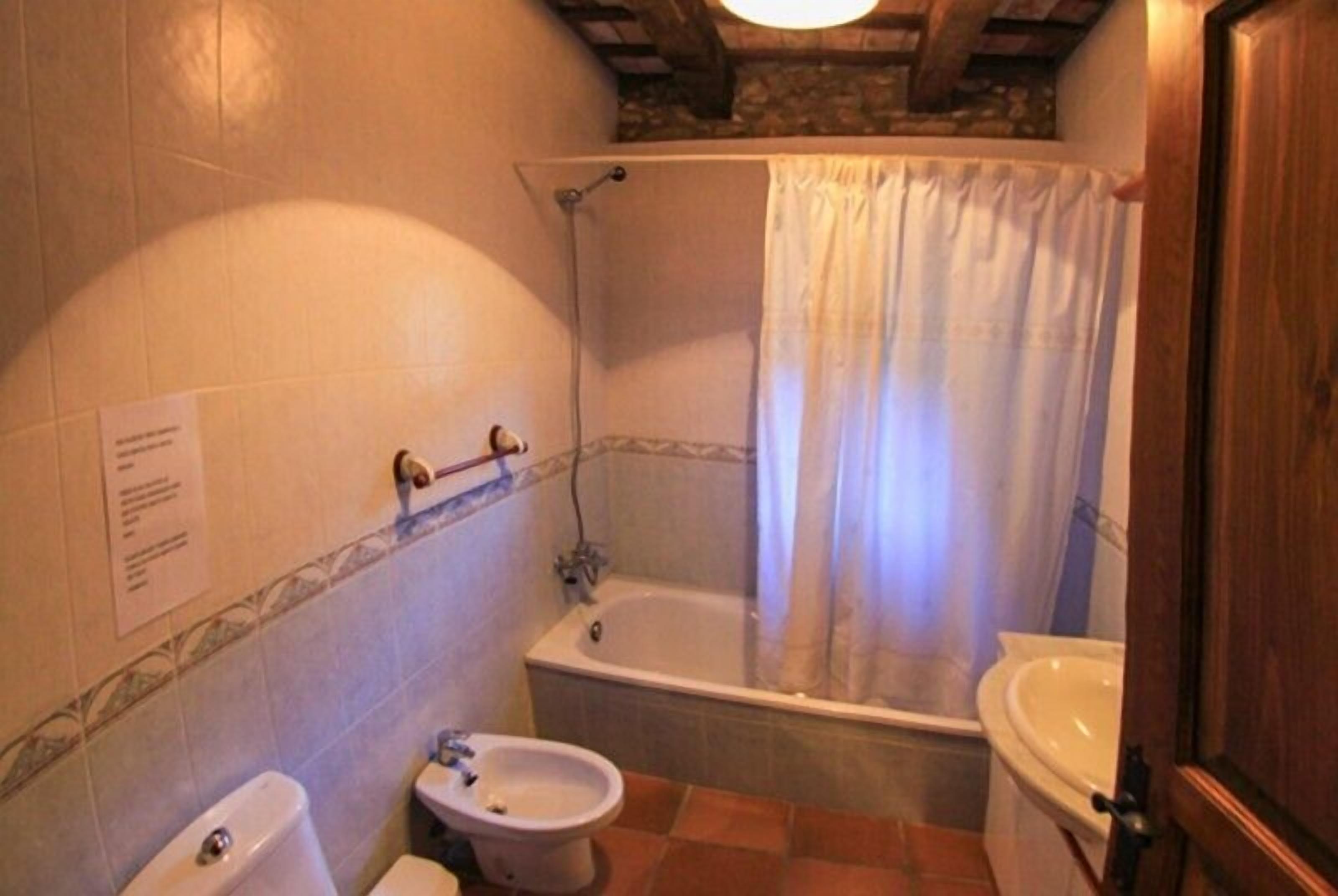 A bathroom with a bathtub, a toilet, and a bidet.