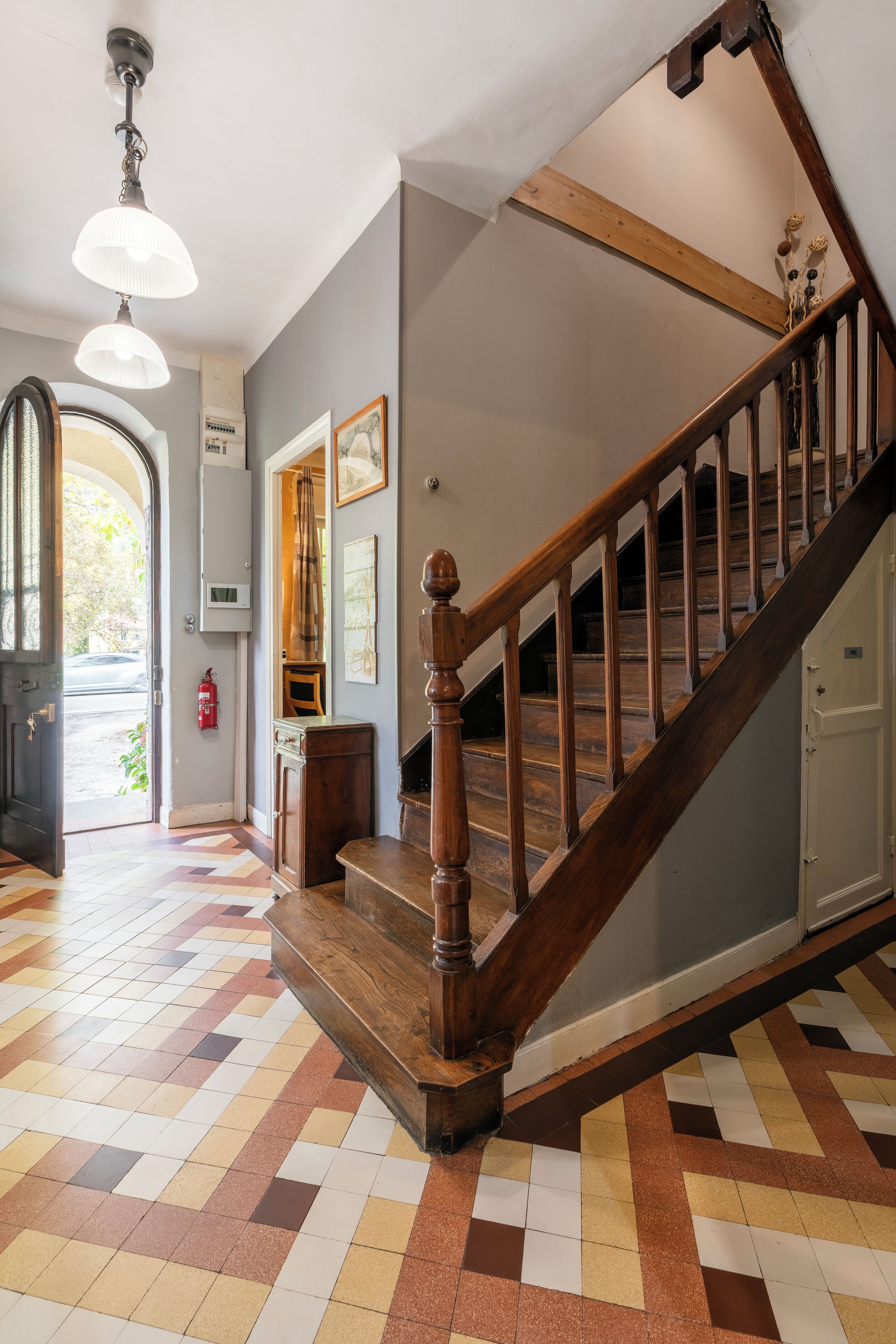 A staircase with wooden balusters and a checkered floor pattern.