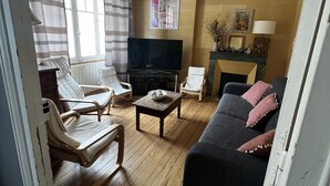 A living room with a sofa, chairs, a TV, and a fireplace.