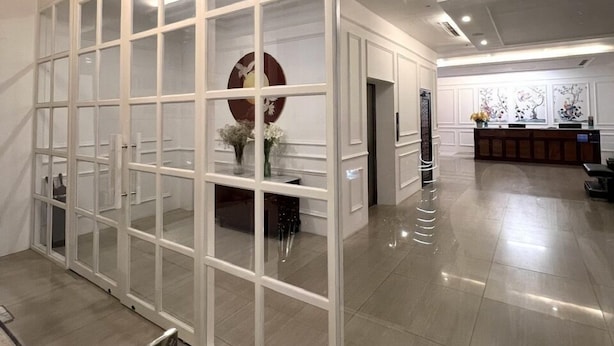 A spacious lobby with a modern design, featuring a glass partition, a reception desk, and a decorative wall. - Dyn Opera Hotel (Ho Chi Minh City)