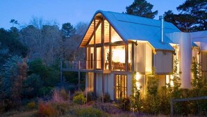 A modern house with a sloped roof, large windows, and a balcony. - Hepburn Spa Pavilions (Hepburn Springs)