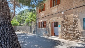 Un edificio de piedra con una puerta, un letrero que indica servicio ETV y un árbol en primer plano.