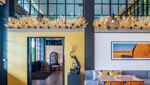 A modern interior with a dining area, a sofa, and a wall-mounted sculpture. - Mayson Place (Samut Prakan)