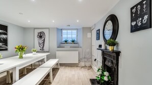 Una cocina moderna con encimera blanca, estufa negra y una ventana sobre el lavamanos.