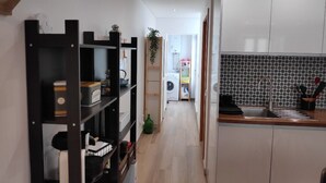 A modern kitchen with white cabinets, a black countertop, and a tiled backsplash.