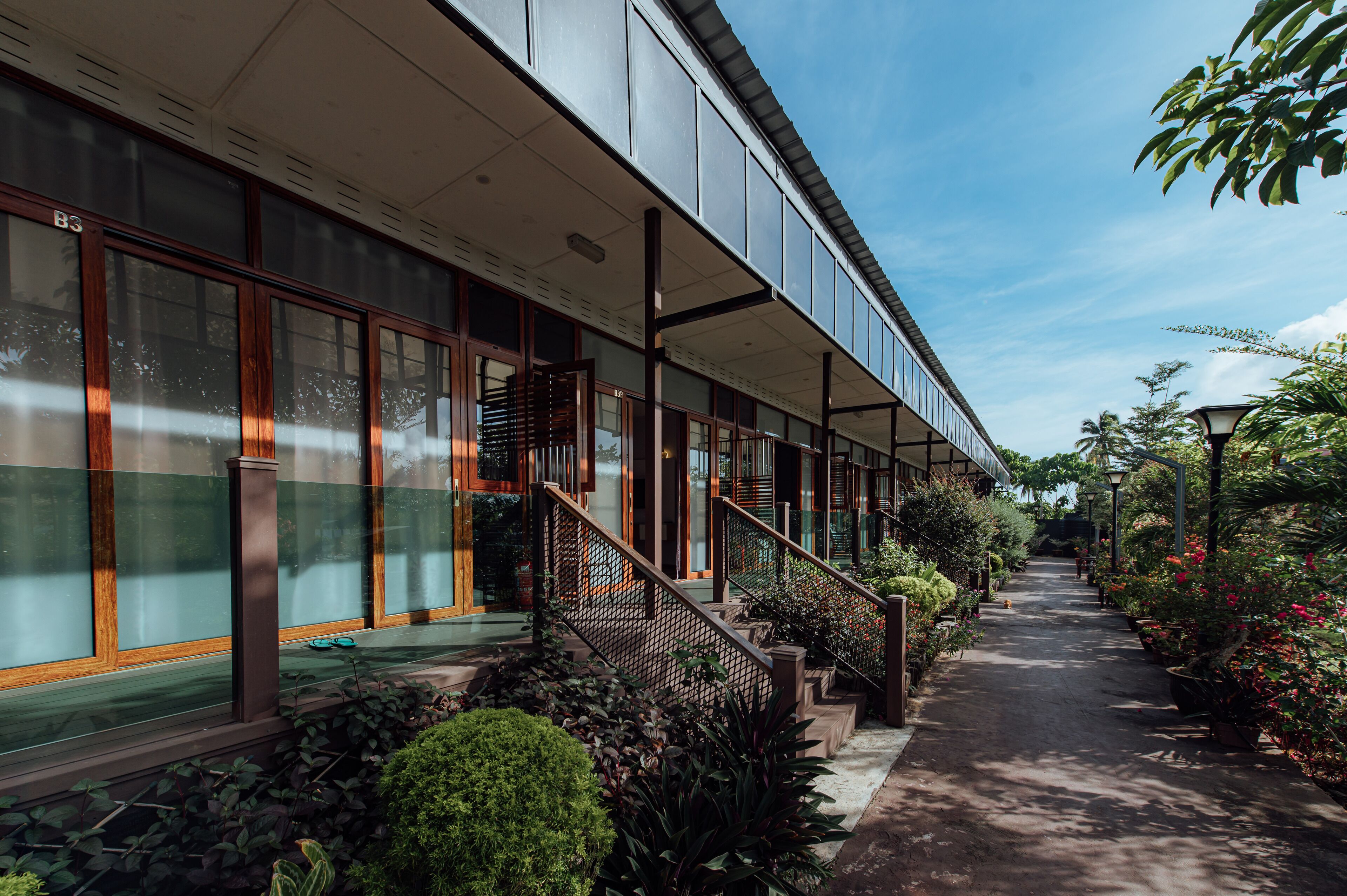 Un edificio moderno con grandes ventanales, una galería techada y una escalera que conduce a la entrada.