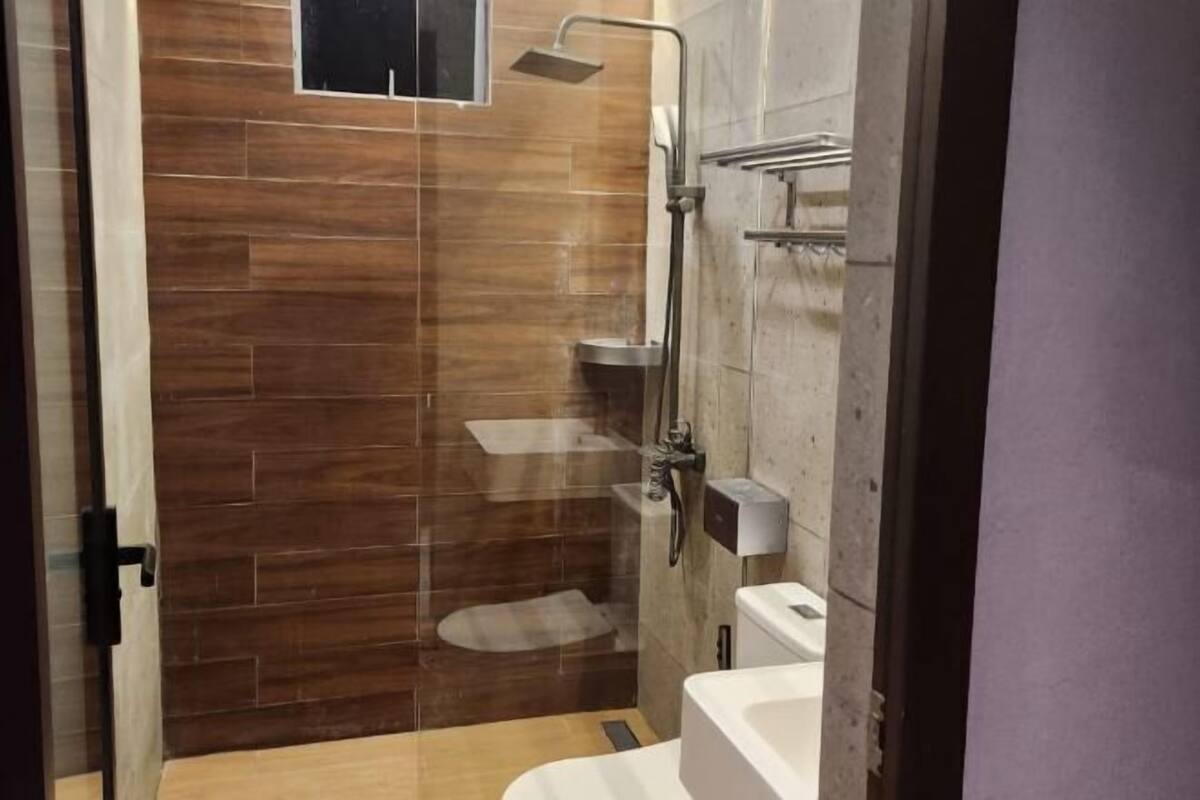 Een douche, pantoffels, een bidet, handdoeken