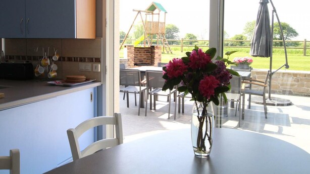 A kitchen with blue cabinets and a dining area with a table and chairs.
