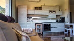 A modern kitchen with built-in cabinets, a central island, and a dining area with a glass table.