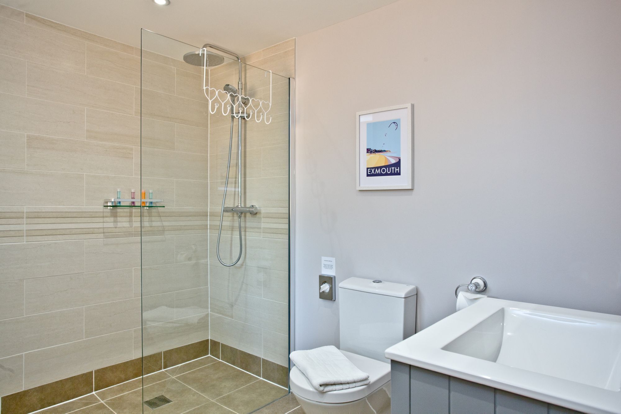 Une salle de bain moderne avec une douche à parois de verre, des toilettes blanches et une baignoire.