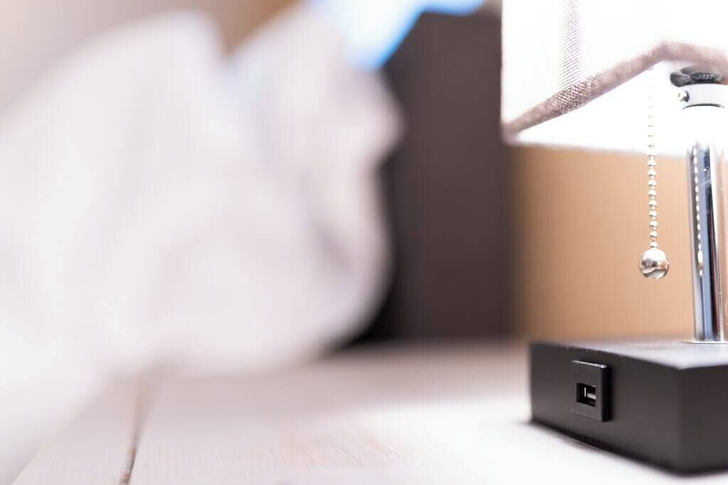 Primer pla d'un dispositiu electrònic negre amb un port USB, possiblement una estació de càrrega, sobre una superfície de fusta.