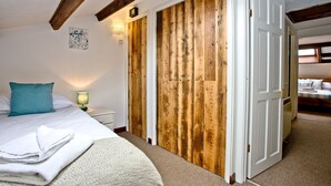 Un dormitorio con una cama, un armario de madera y una mesita de noche con lámpara.