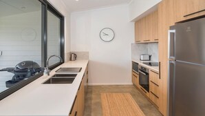 A modern kitchen with a large window, stainless steel appliances, and a clock on the wall. - FortyTwo Mini |Gracetown (Gracetown)