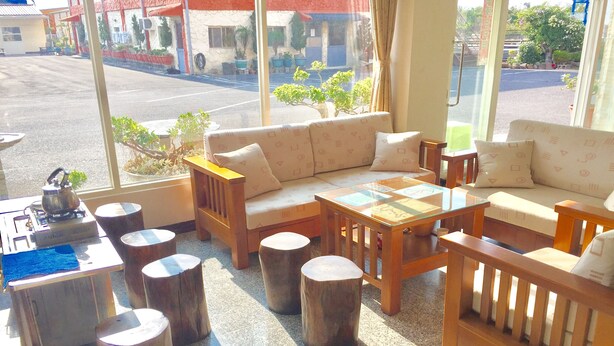 Uma área de estar acolhedora com sofá, mesa de centro e banquinhos de madeira.