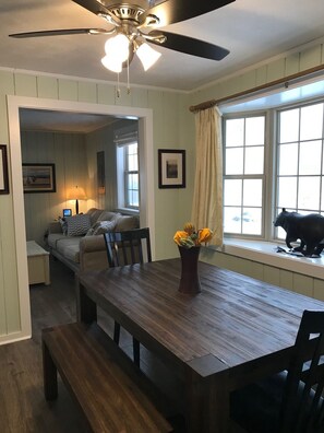 Enjoy meals in this cozy dining area with a table, benches, and a ceiling fan.