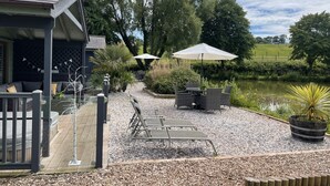 A patio area with outdoor seating, a pool, and a view of the surrounding landscape.