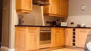 Una cucina con mobili in legno, un fornello e un tostapane.