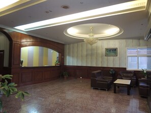 Relax in the spacious lobby with a sofa, armchairs, and a central light fixture.