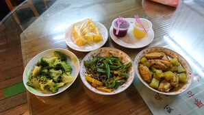 A table with four bowls of food and two plastic cups with straws. - You Ye De Lin B&B (Meishan)