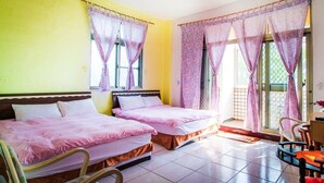A room with two beds, a chair, a small table, and a window with curtains. - You Ye De Lin B&B (Meishan)