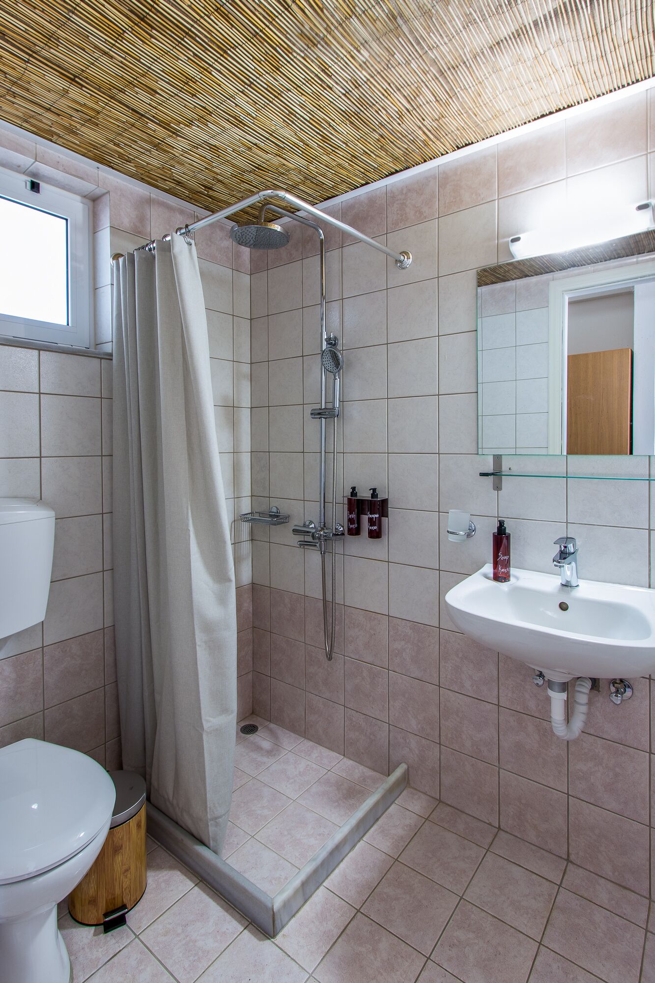 A bathroom with a shower, toilet, and sink.