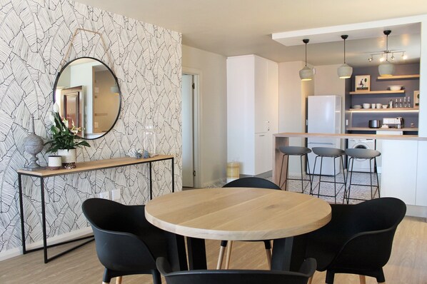 Enjoy meals in this stylish dining area with a round table, mirror, and geometric-patterned walls.