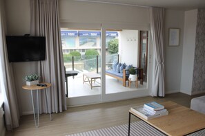 Enjoy a peaceful retreat with a sliding glass door leading to a balcony and a comfortable sofa.