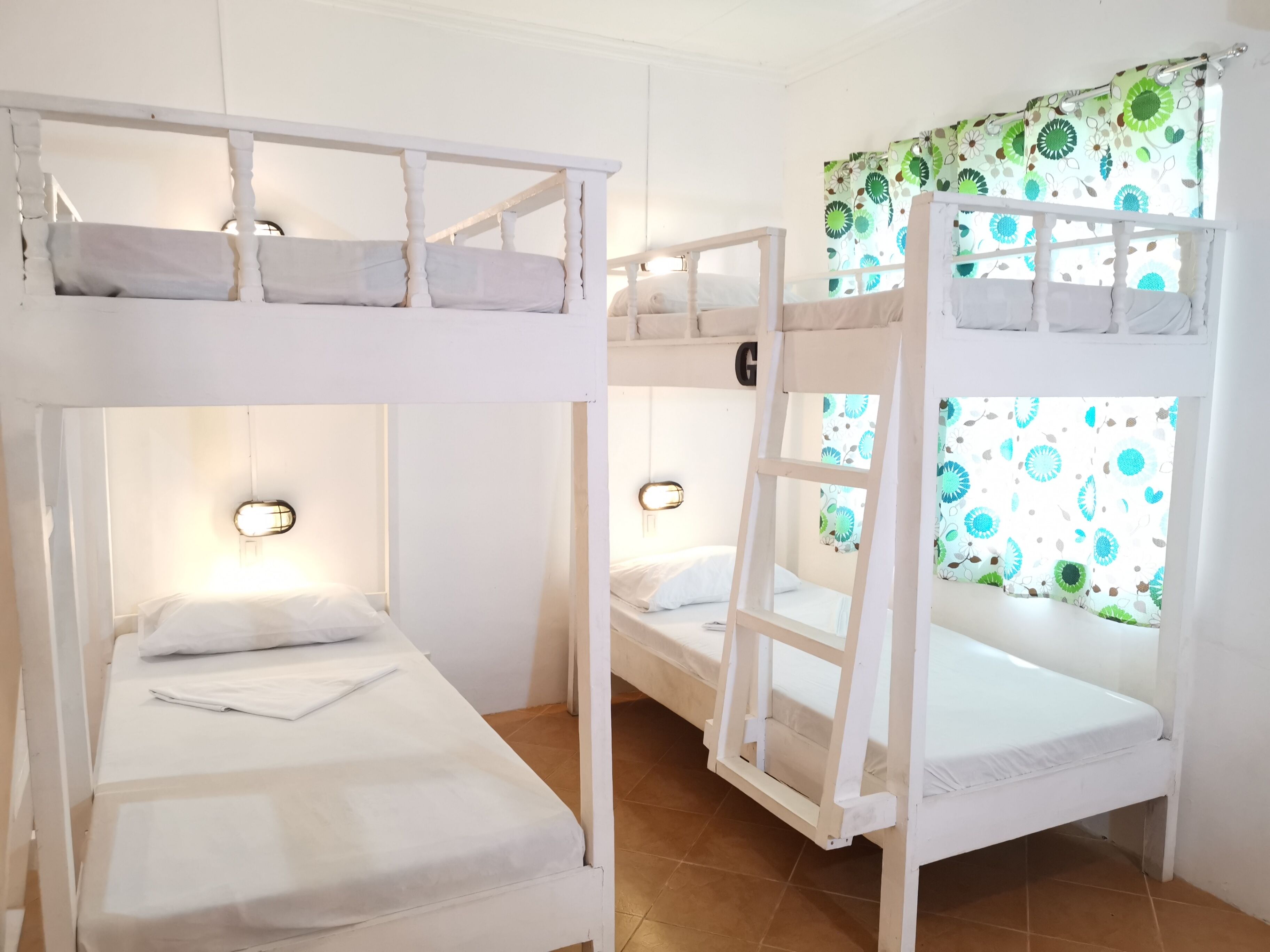 A bunk bed room with two beds, each with a headboard and a small ladder.